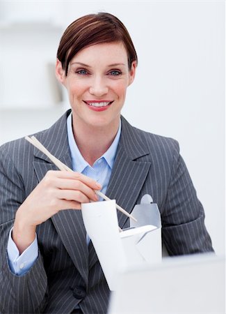 simsearch:689-03124356,k - Businesswoman eating chinese food at work and smiling at the camera Stock Photo - Budget Royalty-Free & Subscription, Code: 400-04660413