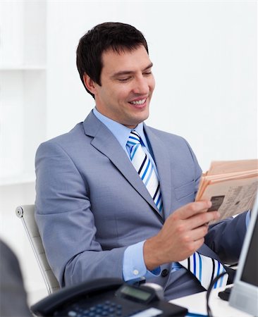 Attractive young businessman reading a newspaper in the office Photographie de stock - Aubaine LD & Abonnement, Code: 400-04660420