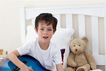 Little boy singing and playing guitar in the bedroom Stock Photo - Budget Royalty-Free & Subscription, Code: 400-04660476
