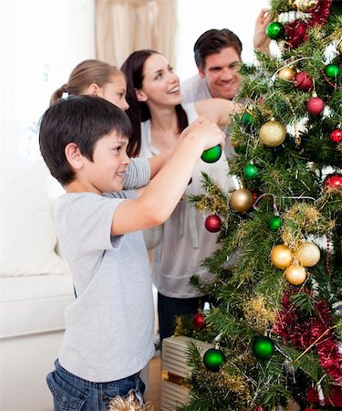 Family decorating a Christmas tree with boubles in the living-room Foto de stock - Super Valor sin royalties y Suscripción, Código: 400-04660697