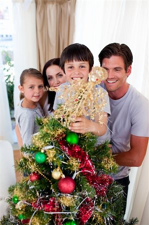 simsearch:400-07088886,k - Happy family decorating a Christmas tree in the living-room Stock Photo - Budget Royalty-Free & Subscription, Code: 400-04660705