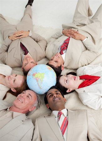 simsearch:400-04187718,k - High angle of International business people lying on the floor around a terrestrial globe Foto de stock - Royalty-Free Super Valor e Assinatura, Número: 400-04662185