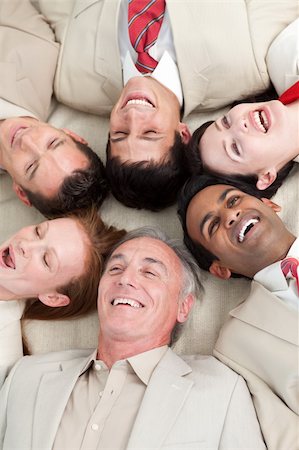 Laughing Business team lying in a circle with heads together Foto de stock - Super Valor sin royalties y Suscripción, Código: 400-04662186