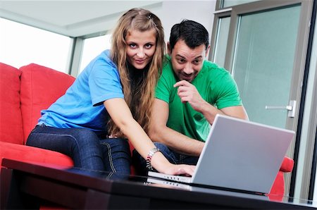 happy young couple have fun and relax at comfort bright apartment and work on laptop computerhappy young couple have fun and relax at comfort bright appartment and work on laptop computer Stock Photo - Budget Royalty-Free & Subscription, Code: 400-04663586