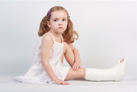 simsearch:846-02791739,k - Little girl injured with broken ankle sitting on white backgound. Stockbilder - Microstock & Abonnement, Bildnummer: 400-04675051