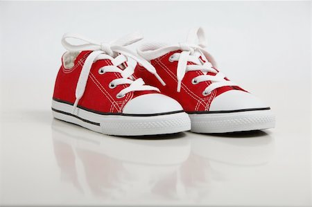 rosliothman (artist) - A pair of new red canvas shoe / sneakers isolated on white with soft reflection. Foto de stock - Super Valor sin royalties y Suscripción, Código: 400-04675068