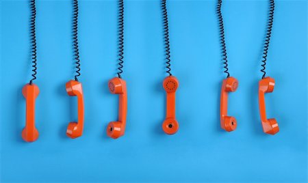 Close-up large group of orange telephones over blue background Fotografie stock - Microstock e Abbonamento, Codice: 400-04675347