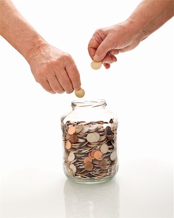 Senior hands collecting coins in a glass jar - saving for retirement concept, isolated Stock Photo - Budget Royalty-Free & Subscription, Code: 400-04677596