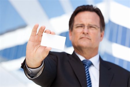 simsearch:400-04963726,k - Handsome Businessman in Suit and Tie Holds Out Blank Business Card in Front of Corporate Building. Stock Photo - Budget Royalty-Free & Subscription, Code: 400-04677909