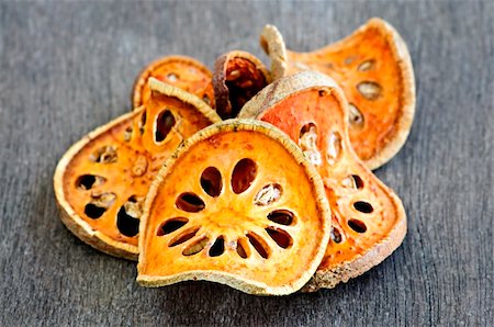 Slices of dried bael fruit on wood surface Foto de stock - Super Valor sin royalties y Suscripción, Código: 400-04678004