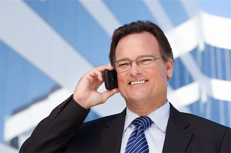 simsearch:400-04608943,k - Confident, Handsome Businessman Smiles as He Talks on His Cell Phone Outdoors. Stock Photo - Budget Royalty-Free & Subscription, Code: 400-04678365