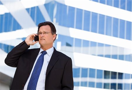 simsearch:400-04608943,k - Concerned, Stressed Businessman Talks on His Cell Phone Outside of Corporate Building. Stock Photo - Budget Royalty-Free & Subscription, Code: 400-04678370