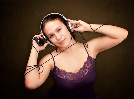 simsearch:400-04681266,k - Pretty girl in funky purple outfit on green background with personal audio device Photographie de stock - Aubaine LD & Abonnement, Code: 400-04678397