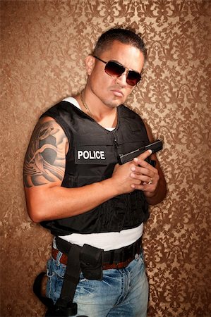 simsearch:400-04172754,k - Hispanic Cop Wearing Bulletproof Vest and Holding Small Gun Stock Photo - Budget Royalty-Free & Subscription, Code: 400-04670591