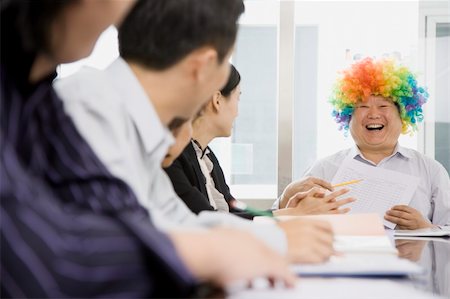fat corporate woman - A man is wearing a clown's wig during a meeting.  He is smiling and looking at his co-workers.  Horizontally framed shot. Foto de stock - Super Valor sin royalties y Suscripción, Código: 400-04671939