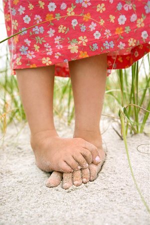 Closeup of a little girl's barefoot feet that are crossed and covered in sand. Vertical shot. Stock Photo - Budget Royalty-Free & Subscription, Code: 400-04671983