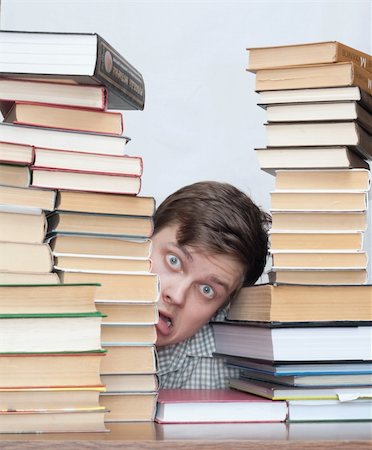 Young crazy student hide behind stacked books Photographie de stock - Aubaine LD & Abonnement, Code: 400-04672136