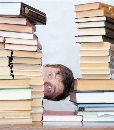 Young surprised student hide behind stacked books Photographie de stock - Aubaine LD & Abonnement, Code: 400-04672138
