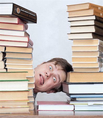 Young unhappy student with one's tongue hanging out and stacked books Photographie de stock - Aubaine LD & Abonnement, Code: 400-04672139