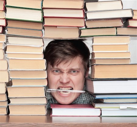 sad and happy school students - Young crazy student with pen in teeth between books Stock Photo - Budget Royalty-Free & Subscription, Code: 400-04672131