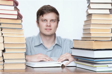 simsearch:400-04622920,k - Young happy student reading book between books Fotografie stock - Microstock e Abbonamento, Codice: 400-04672147