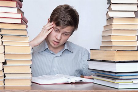 simsearch:400-04622920,k - Young worried student reading philosophy between books Fotografie stock - Microstock e Abbonamento, Codice: 400-04672159