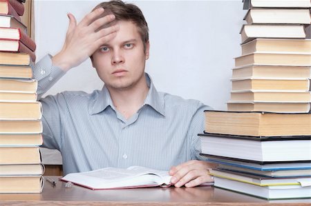 simsearch:400-04622920,k - Young crazy discontent student put hand to forehead between books Fotografie stock - Microstock e Abbonamento, Codice: 400-04672162