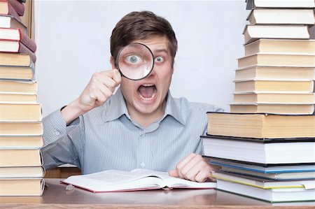 simsearch:400-04622920,k - Young crazy student shout between books and hold loupe in the face of Fotografie stock - Microstock e Abbonamento, Codice: 400-04672236