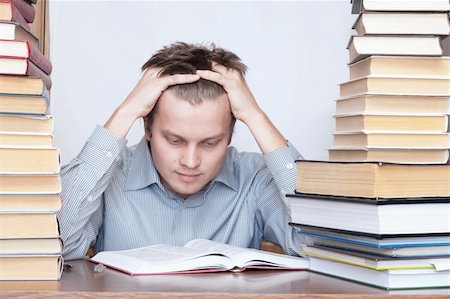 simsearch:400-04622920,k - Young student sitting between books and reading thinking Fotografie stock - Microstock e Abbonamento, Codice: 400-04672238