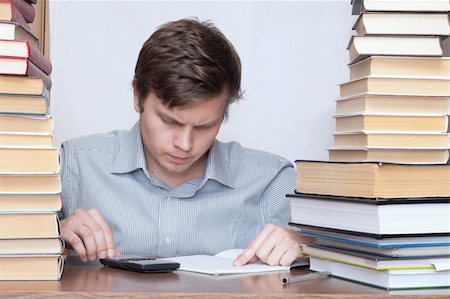 Young student sitting between books and calculate Photographie de stock - Aubaine LD & Abonnement, Code: 400-04672240