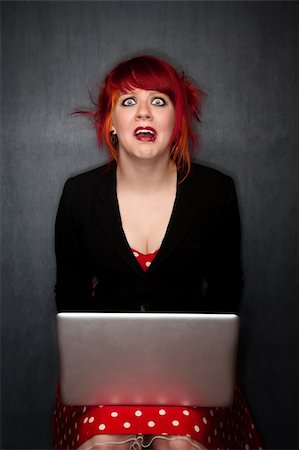 simsearch:400-06330521,k - Pretty punky girl with brightly dyed red hair with laptop computer Photographie de stock - Aubaine LD & Abonnement, Code: 400-04672468