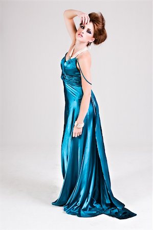 simsearch:400-04672924,k - Attractive young woman standing in a blue satin dress, wearing pearls and touching her head. Vertical shot. Photographie de stock - Aubaine LD & Abonnement, Code: 400-04672901
