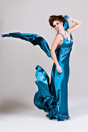 simsearch:400-04672946,k - Attractive young woman standing in a blue satin dress as it blows in the wind. Vertical shot. Stock Photo - Budget Royalty-Free & Subscription, Code: 400-04672902