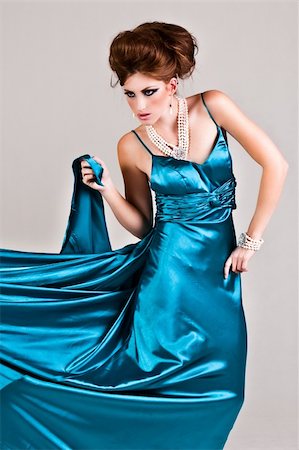 simsearch:400-04672926,k - Attractive young woman standing in a blue satin dress that is being pulled to the side. Vertical shot. Foto de stock - Super Valor sin royalties y Suscripción, Código: 400-04672903