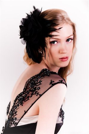 simsearch:400-04672923,k - Attractive young woman looking over her shoulder. She is wearing a black lace top and a black feather hairdressing. Vertical shot. Isolated on white. Photographie de stock - Aubaine LD & Abonnement, Code: 400-04672940