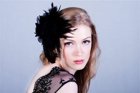 simsearch:400-04672946,k - Attractive young woman wearing a black lace top and a black feather hairdressing. She is looking over her shoulder. Horizontal shot. Stock Photo - Budget Royalty-Free & Subscription, Code: 400-04672941