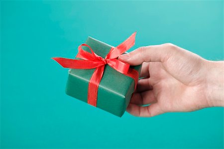 Hand holding a small green gift with red ribbon. Stock Photo - Budget Royalty-Free & Subscription, Code: 400-04673286