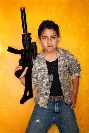 soldier character - Handsome young Hispanic in front of yellow wall with toy gun Stock Photo - Budget Royalty-Free & Subscription, Code: 400-04684156