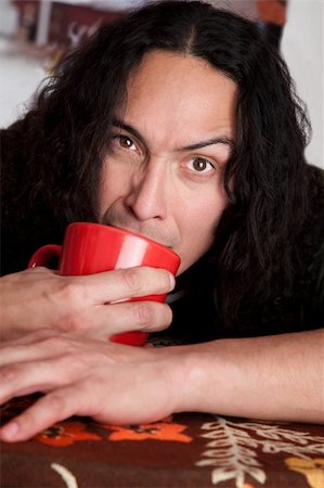 simsearch:400-04554624,k - Tired Latino man cradling red coffee cup Stock Photo - Budget Royalty-Free & Subscription, Code: 400-04684158