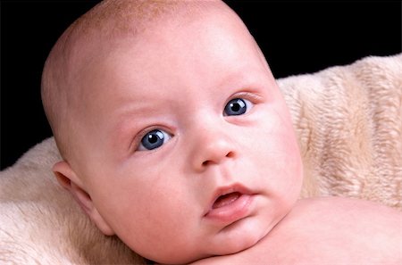 selloutphotos (artist) - 3 month old baby boy with blue eyes lying on a fluffy blanket on a black background Stockbilder - Microstock & Abonnement, Bildnummer: 400-04684335