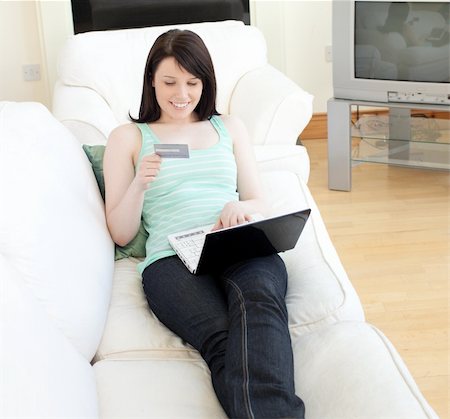 simsearch:6109-06194304,k - Charming woman shopping on-line lying on a sofa at home Fotografie stock - Microstock e Abbonamento, Codice: 400-04686838