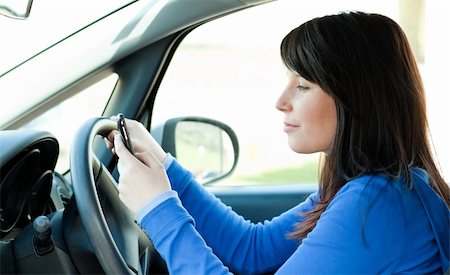 Attractive brunette teen girl using a mobile phone while driving Stock Photo - Budget Royalty-Free & Subscription, Code: 400-04686893