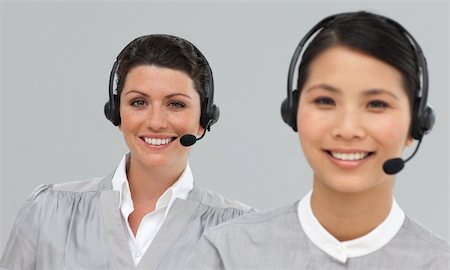 simsearch:400-03912315,k - Smiling young businesswomen with headset on looking at the camera Photographie de stock - Aubaine LD & Abonnement, Code: 400-04687165