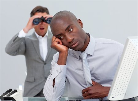 simsearch:400-04591983,k - Afro-amercian businessman annoyed by a man looking through binoculars in the office Fotografie stock - Microstock e Abbonamento, Codice: 400-04687318