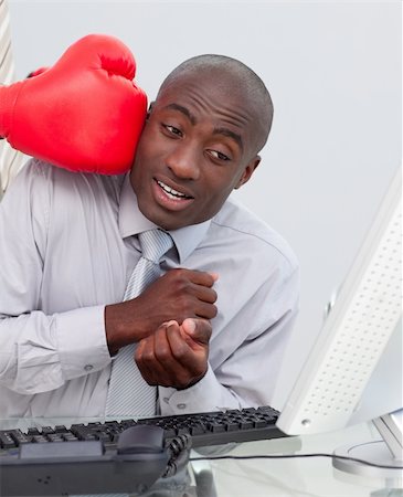 person punching for victory - Ethnic businessman hit by a boxing glove in his office Stock Photo - Budget Royalty-Free & Subscription, Code: 400-04687311
