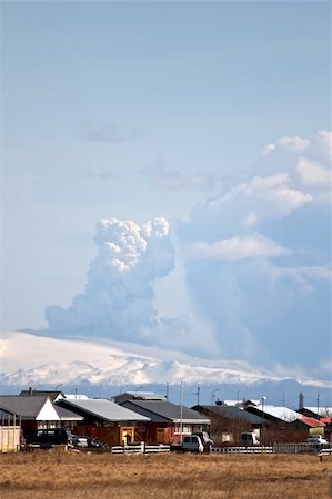 The Eyjafjallajokull glacier and volcano in southern Iceland. The volcano erupted in March 2010. Houses from a small nearby city is seen in the foreground. Stock Photo - Budget Royalty-Free & Subscription, Code: 400-04688551