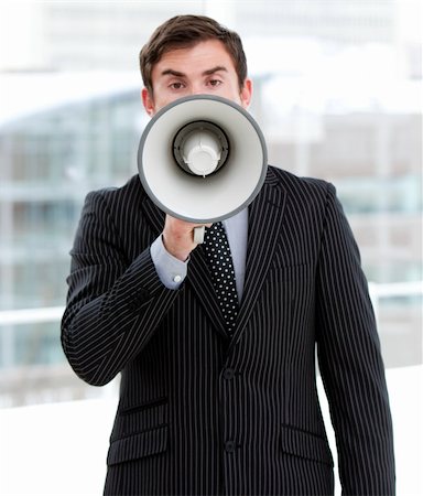 simsearch:400-04126489,k - Stressed businessman yelling through a megaphone standing in the office Stock Photo - Budget Royalty-Free & Subscription, Code: 400-04689177