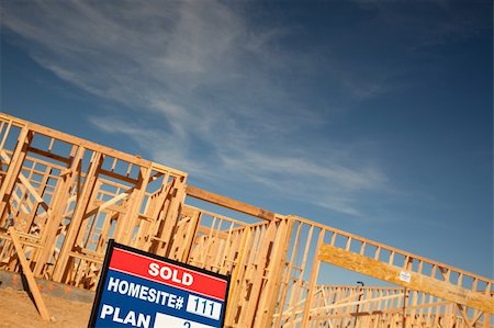 family with sold sign - Sold Lot Real Estate Sign at New Home Framing Construction Site Against Deep Blue Sky. Stock Photo - Budget Royalty-Free & Subscription, Code: 400-04689750