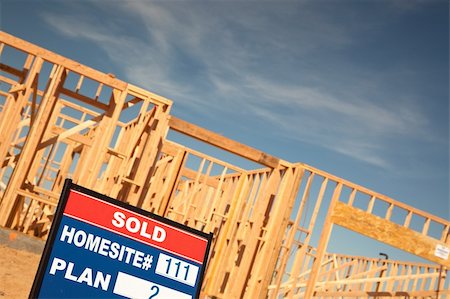 family with sold sign - Sold Lot Real Estate Sign at New Home Framing Construction Site Against Deep Blue Sky. Stock Photo - Budget Royalty-Free & Subscription, Code: 400-04689751