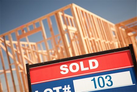 family with sold sign - Sold Lot Real Estate Sign at New Home Framing Construction Site Against Deep Blue Sky. Stock Photo - Budget Royalty-Free & Subscription, Code: 400-04689752